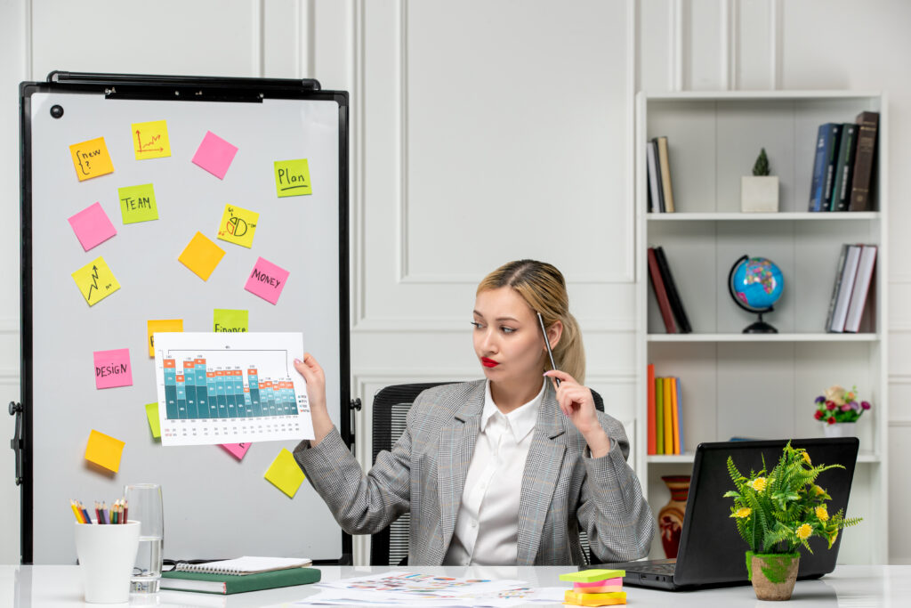 marketing young cute blonde girl grey suit office holding pen statistics